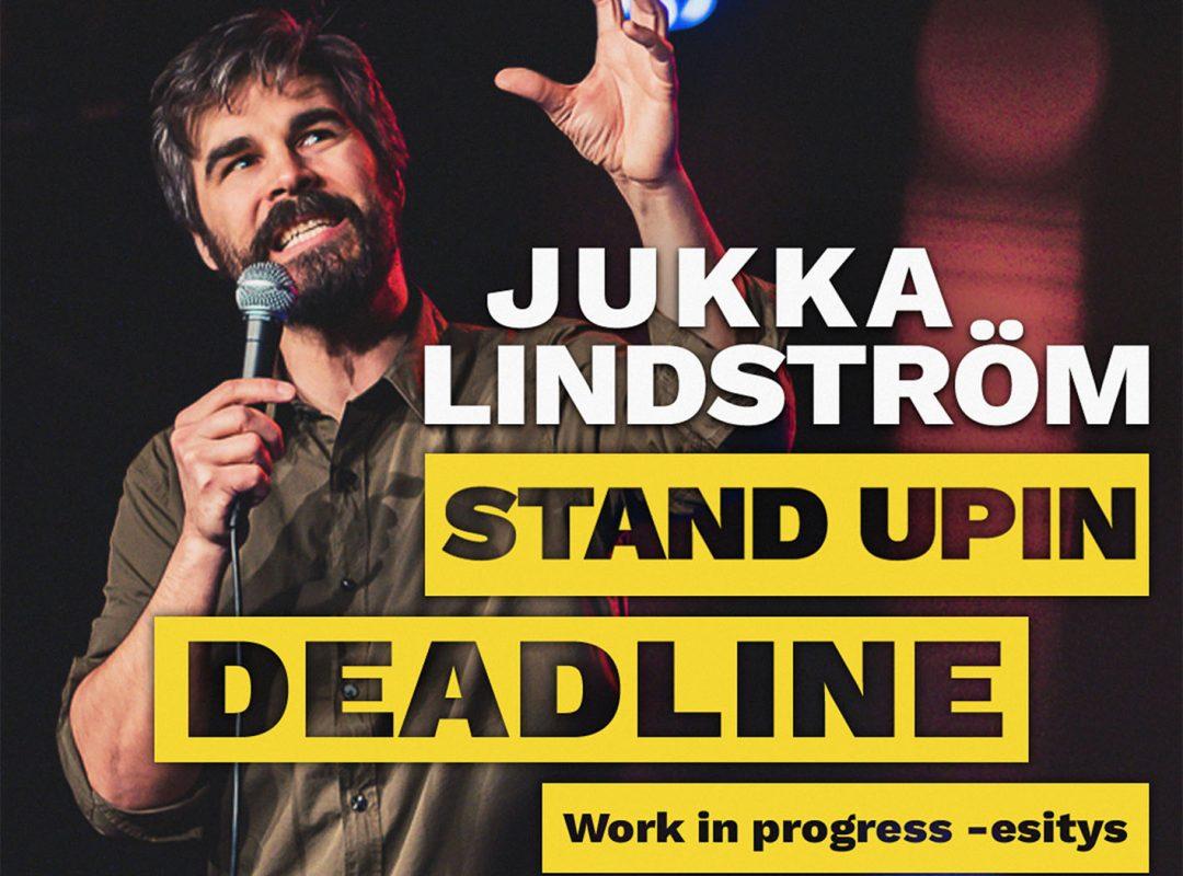 Kuvassa Jukka Lindström mikrofonin kanssa sekä edessä keltaisella pohjalla tapahtuman nimi Stand upin deadline.